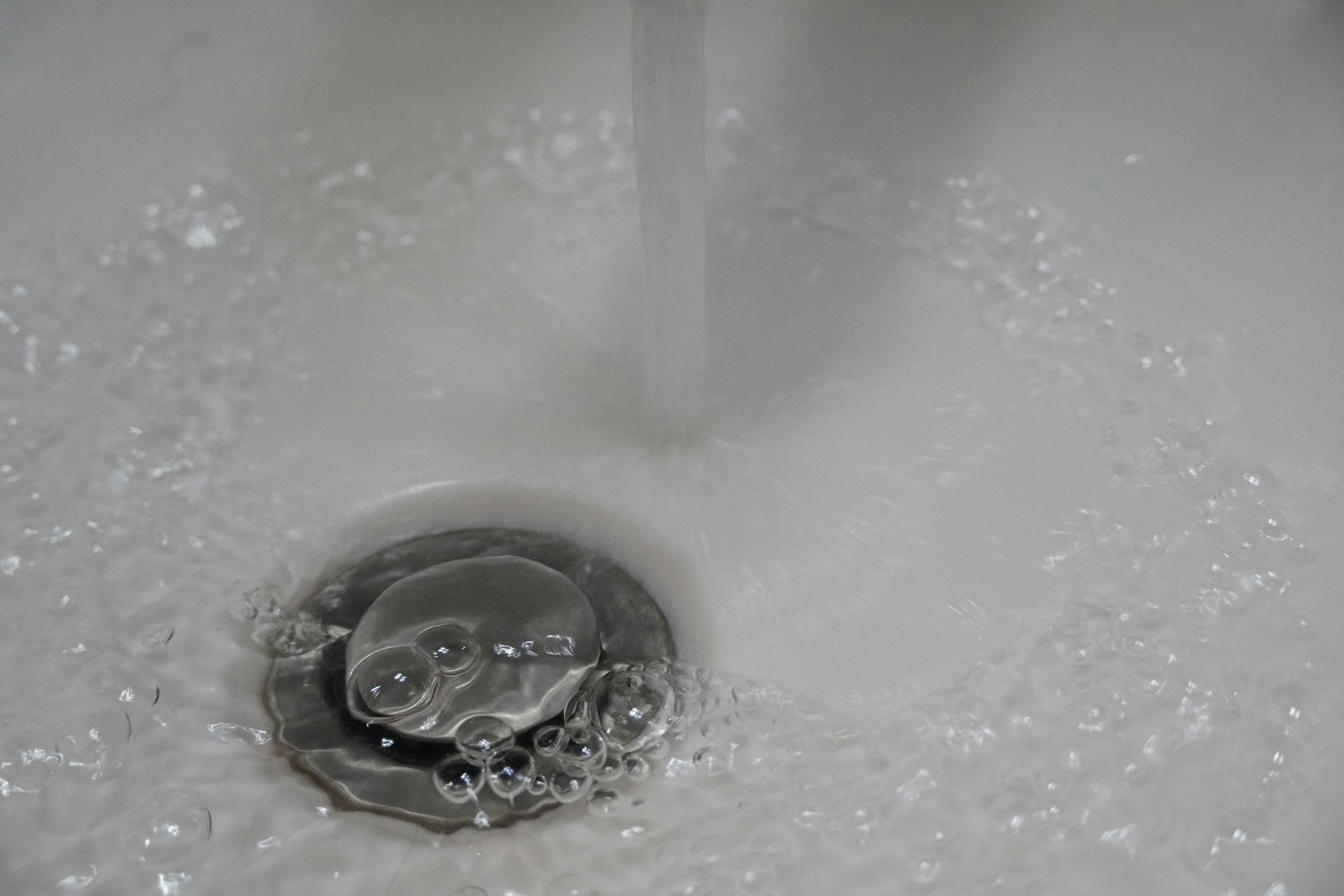 Luftblasen im Wasser eines Abflusses